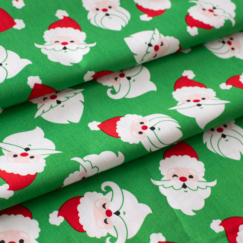 Katoenen-kerststof-met-de-kerstman-op-een-groene-achtergond